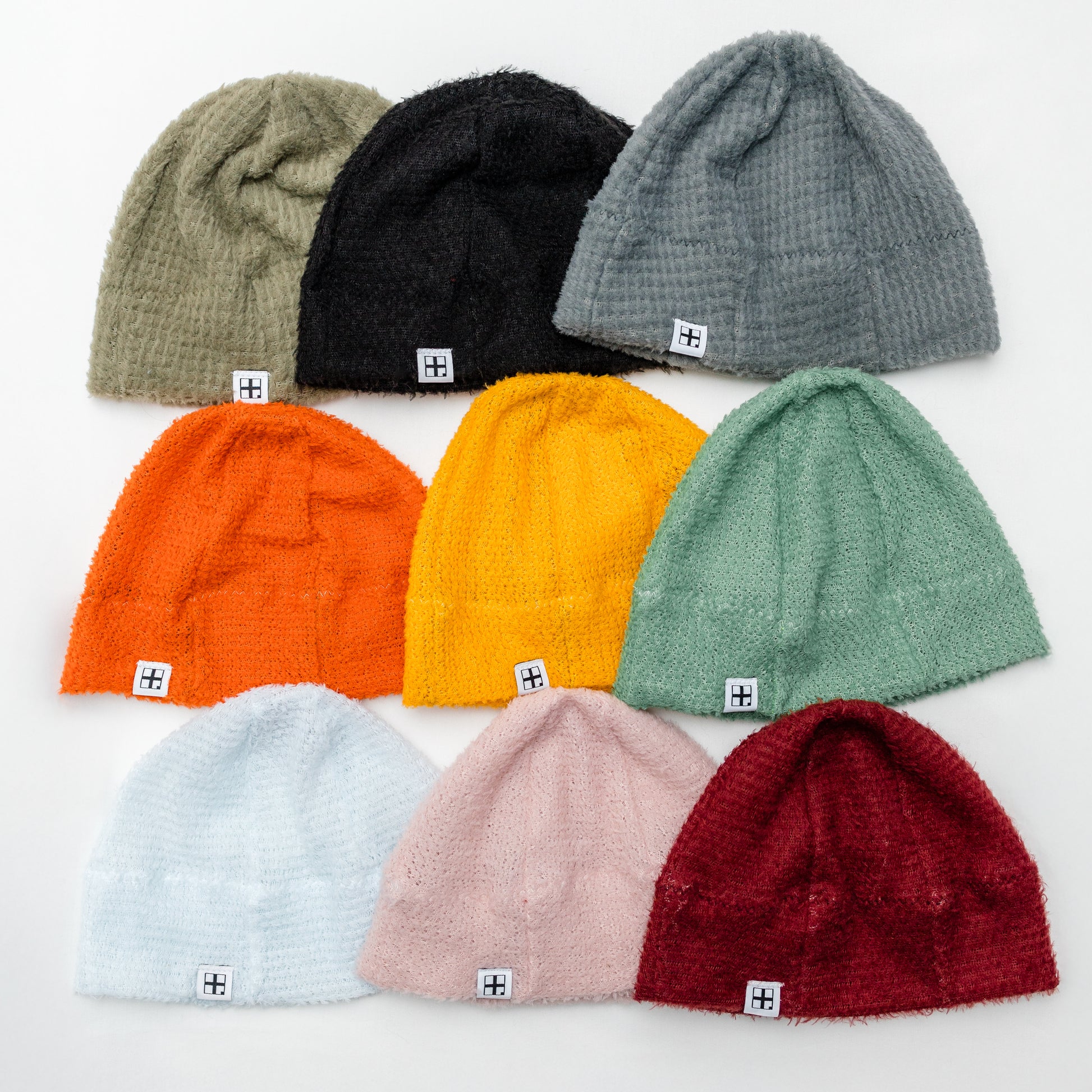 Alpha Direct Ultralight Beanies displayed on a white background, including colors such as black, gray, orange, yellow, green, pink, and red.